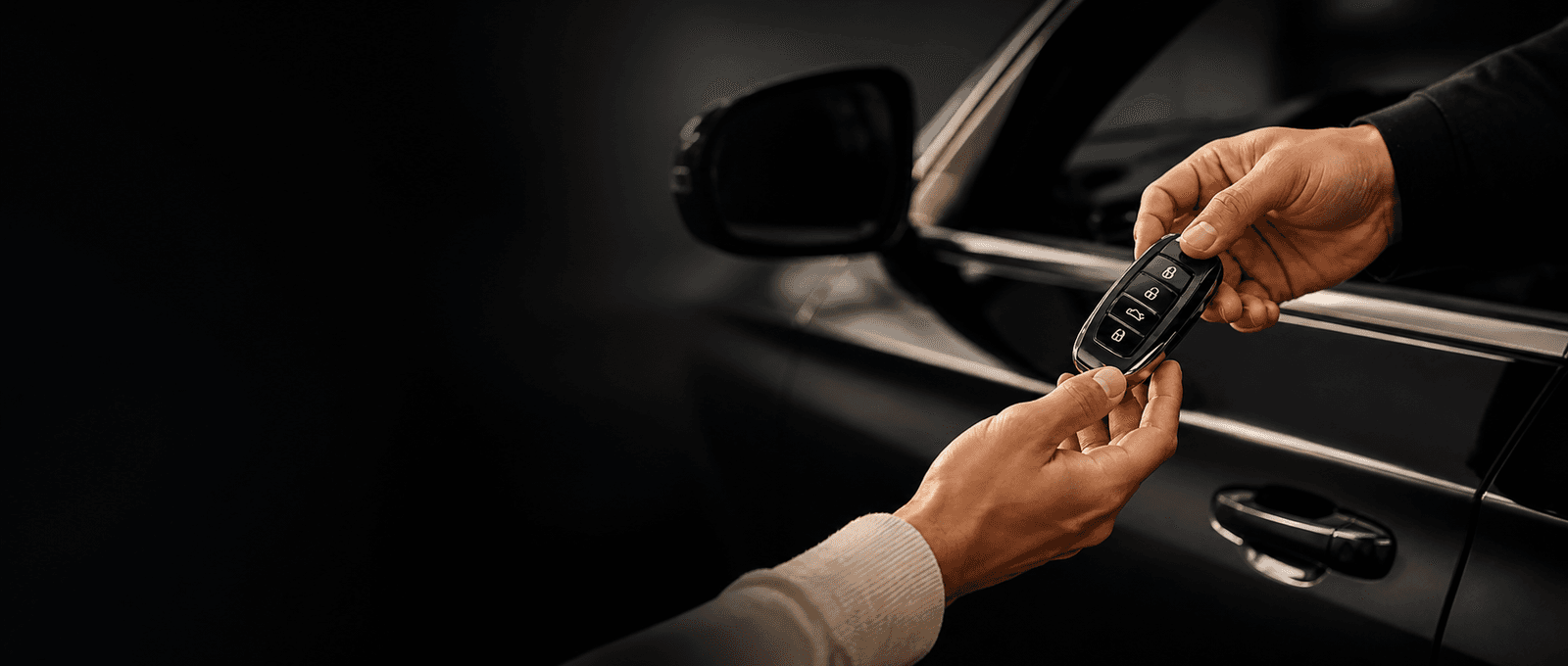 Manos intercambiando las llaves de un auto